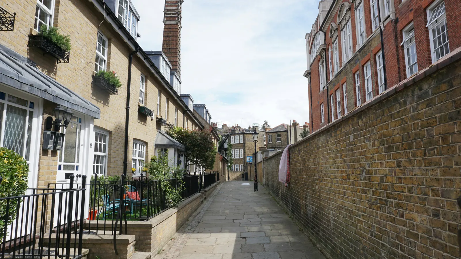 A narrow brick-walled passage between London houses